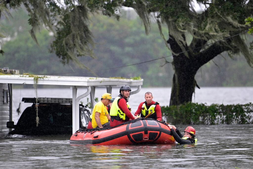First responders with Orange County Fire Rescue use an inflatable boat to rescue a resident from a home in the aftermath of Hurricane Ian, Thursday, Sept. 29, 2022, in Orlando, Fla. (AP Photo/Phelan M. Ebenhack)
