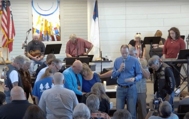 Members of First Baptist Church Sutherland Springs, Texas, gather around their pastor Frank Pomeroy and his wife Sherri Sunday, Sept. 25, after Pomeroy preached his last sermon as pastor.