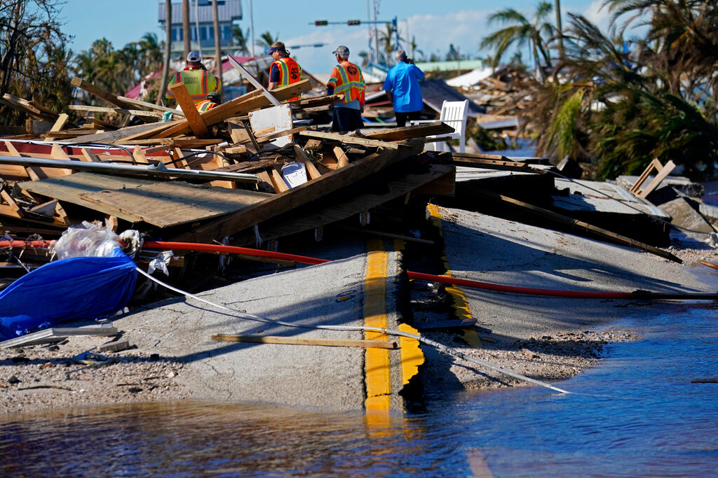 Responders survey damage to the bridge leading to Pine Island in the aftermath of Hurricane Ian in Matlacha, Fla., Sunday, Oct. 2, 2022. The only bridge to the island is heavily damaged so it can only be reached by boat or air. (AP Photo/Gerald Herbert)