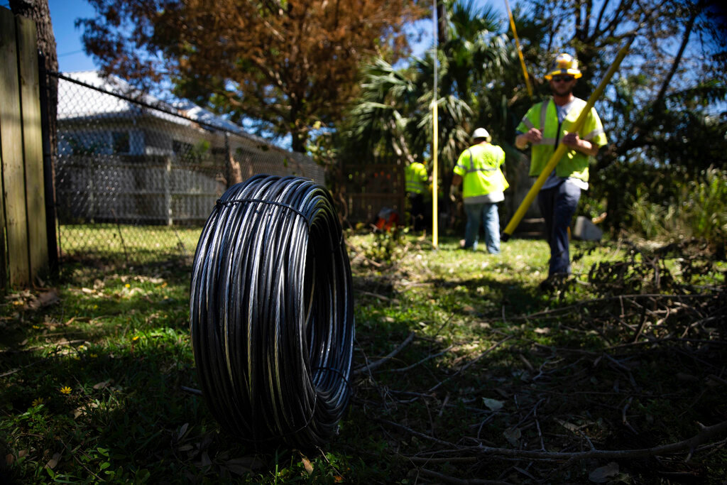 Workers for Florida Power and Electric repair a power line damaged by Hurricane Ian in Naples, Fla., on Monday, Oct. 3, 2022. (AP Photo/Robert Bumsted)