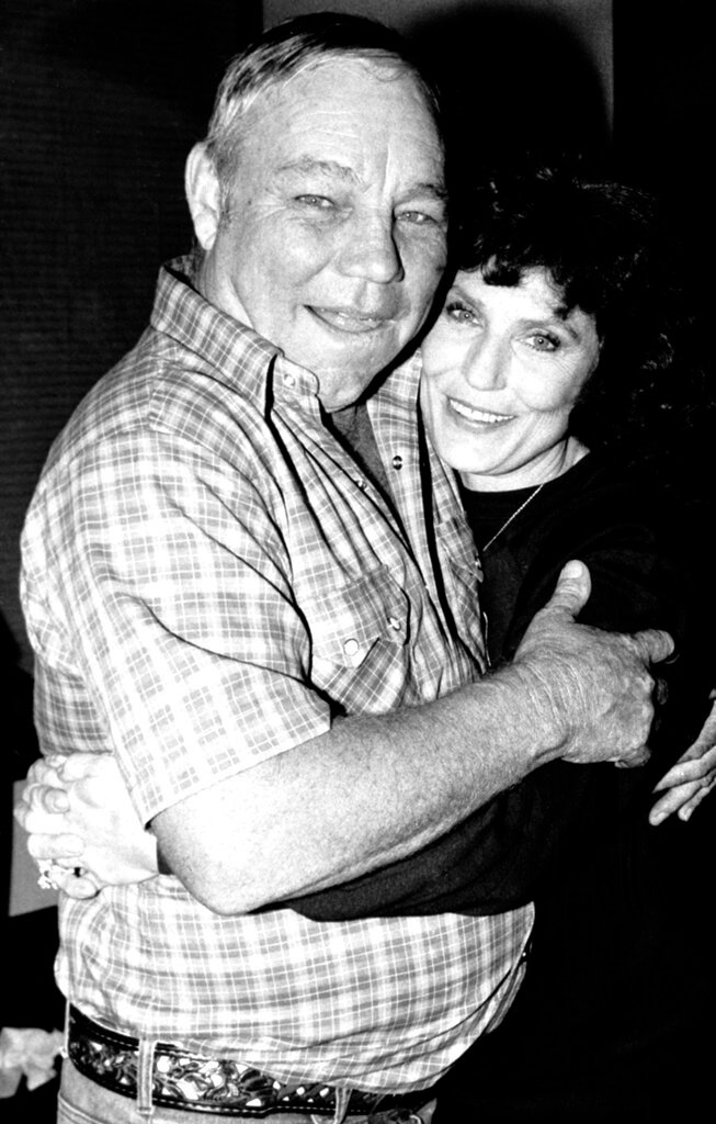Country music singer Loretta Lynn embraces her husband, Oliver "Mooney" Lynn, during rehearsal for her New York debut, on Oct. 21, 1982. (AP Photo/Antonio Carozza, File)