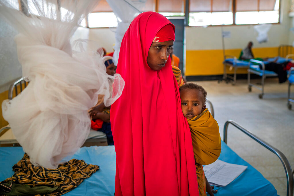 A woman holds a child at a clinic in Dollow, Somalia, Sept. 21, 2022. (AP Photo/Jerome Delay)