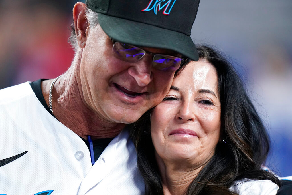 Miami Marlins manager Don Mattingly hugs his wife Lori Mattingly as he is recognized on the field during the fifth inning against the Atlanta Braves, Wednesday, Oct. 5, 2022, in Miami. (AP Photo/Wilfredo Lee)