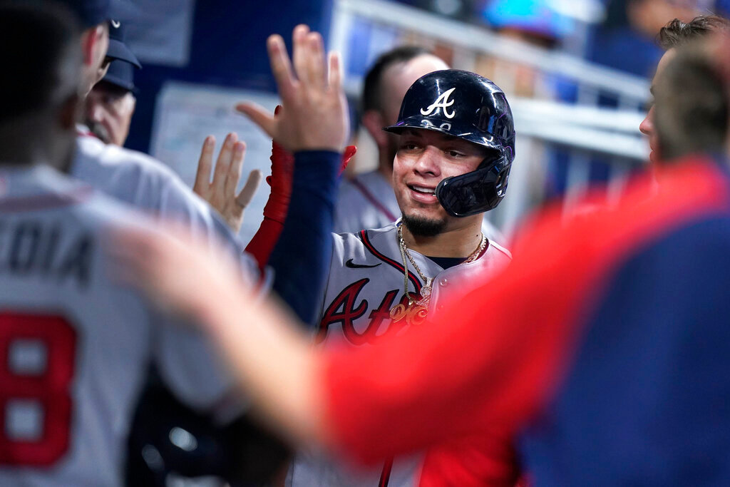 Atlanta Braves' William Contreras is congratulated by teammates after he scored on a single by Eddie Rosario during the fourth inning against the Miami Marlins, Wednesday, Oct. 5, 2022, in Miami. (AP Photo/Wilfredo Lee)