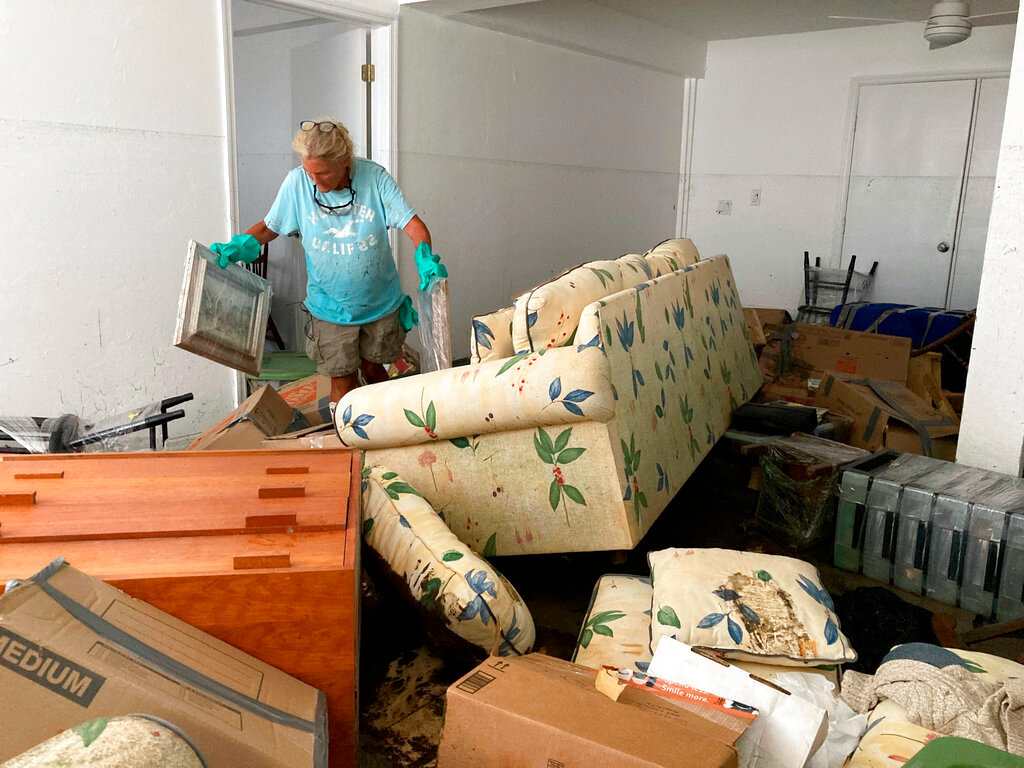 Resident Pamela Brislin cleans up the damage from Hurricane Ian, Thursday, Oct. 6, 2022, in Sanibel Island, Fla. (AP Photo/Scott Smith)