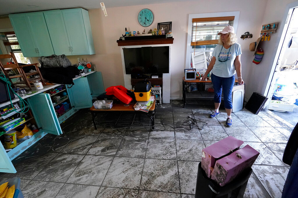 Cindy Bickford looks over her home damaged in Hurricane Ian, Thursday, Oct. 6, 2022, in Pine Island, Fla. (AP Photo/Wilfredo Lee)