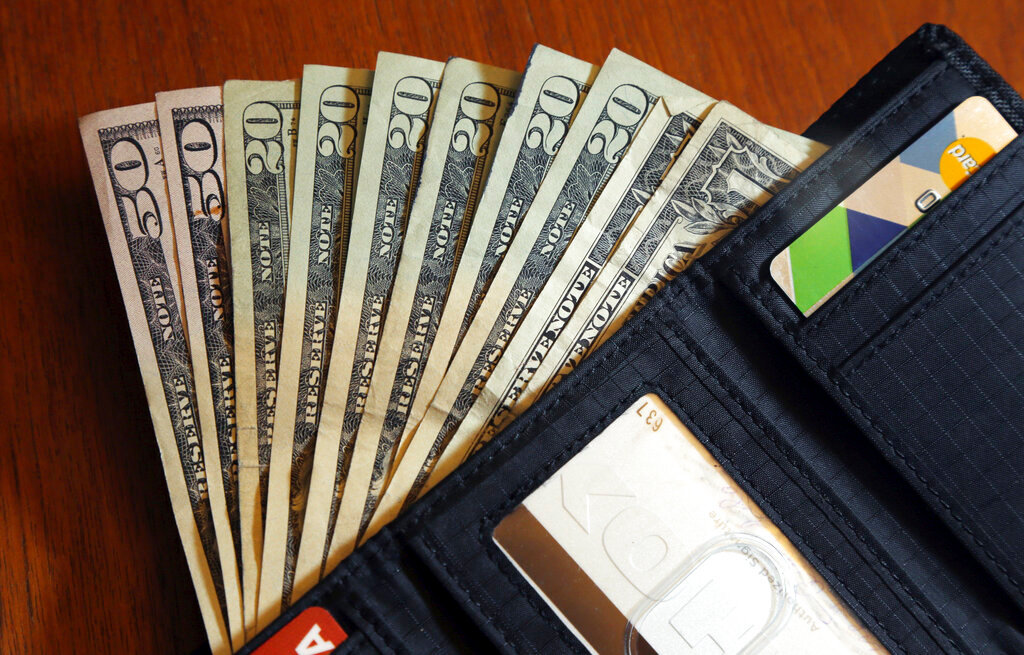 In this June 15, 2018, file photo, cash is fanned out from a wallet in North Andover, Mass. (AP Photo/Elise Amendola, File)