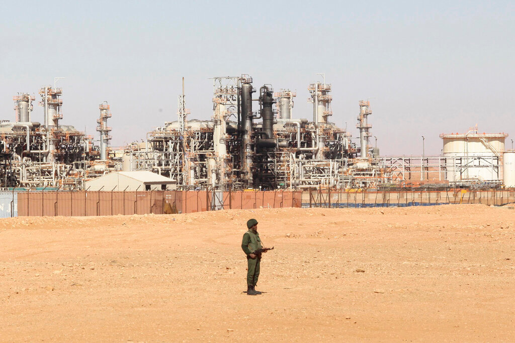 An Algerian soldier stands guard during a visit for news media, organized by the Algerian authorities, at the gas plant in Ain Amenas, seen in background, Jan. 31, 2013. (AP Photo, File)