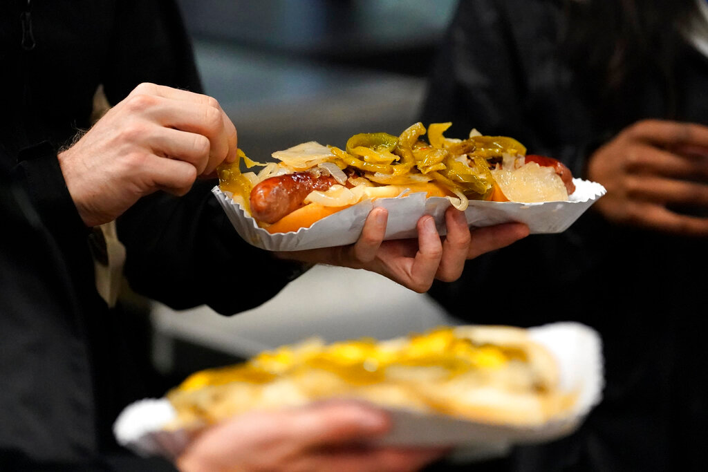 A baseball fan picks at the onions on their hotdog during a baseball game between the Cleveland Guardians and Chicago White Sox Tuesday, Sept. 20, 2022, in Chicago. (AP Photo/Charles Rex Arbogast)