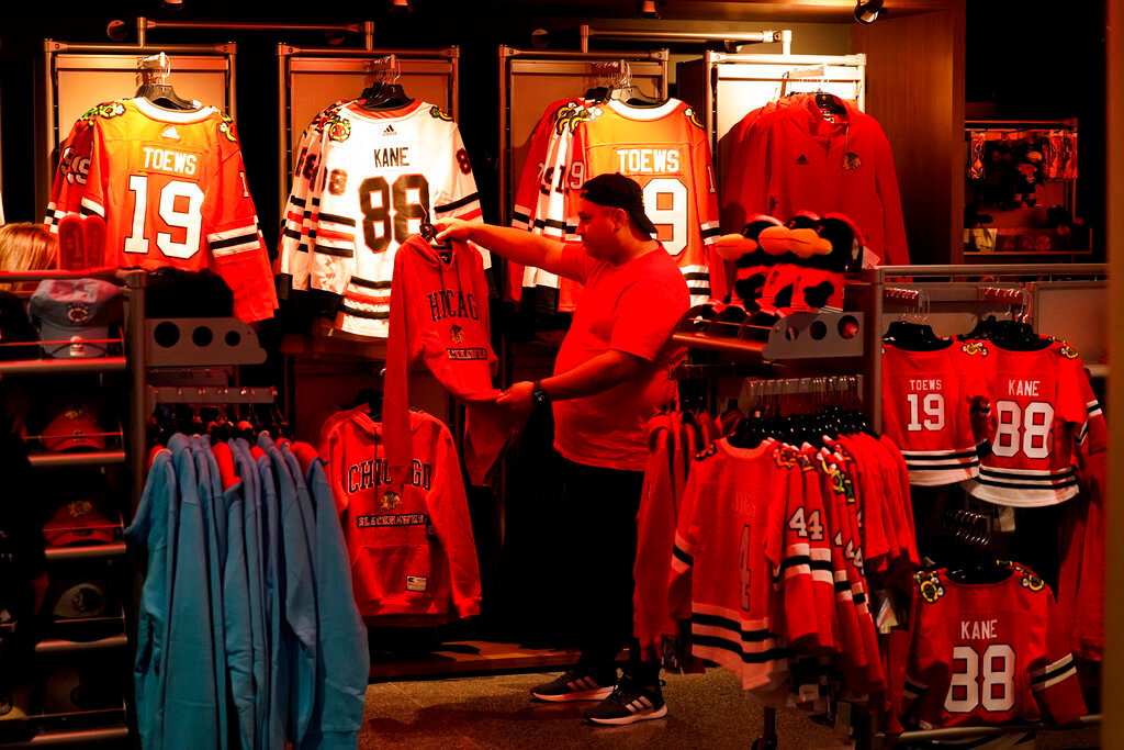 A Chicago Blackhawks fan shops at a team apparel store in the United Center before an NHL game between the Blackhawks and the Florida Panthers, Tuesday, Oct. 25, 2022, in Chicago. (AP Photo/Charles Rex Arbogast)