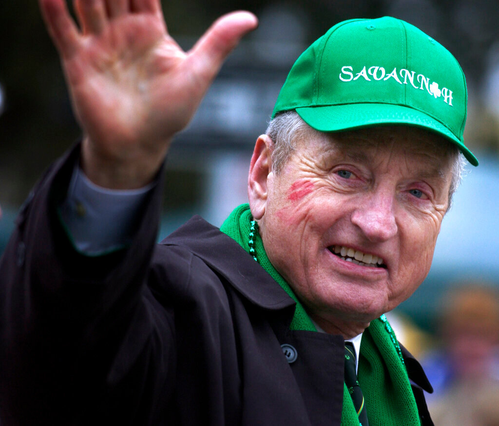 Former University of Georgia football coach and athletic director Vince Dooley waves to the crowd Thursday, March 17, 2005, after getting kissed on the cheek by a fan during the St. Patrick's Day parade in Savannah, Ga. (AP Photo/Stephen Morton, File)