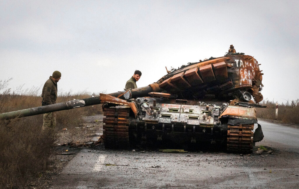 Ukrainian soldiers inspect a damaged Russian tank on a road near the recently retaken village of Kamianka, Kharkiv region, Ukraine, Sunday, Oct. 30, 2022.(AP Photo/Efrem Lukatsky)
