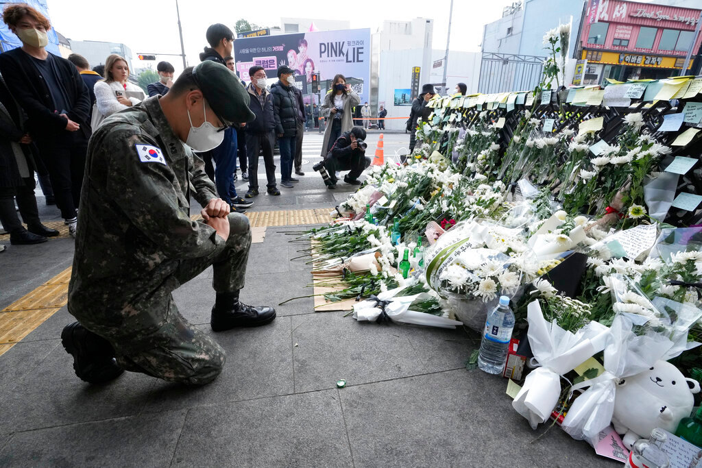 A South Korean army soldier pays tribute to victims of a deadly accident following Saturday night's Halloween festivities on a street near the scene in Seoul, South Korea, Tuesday, Nov. 1, 2022. (AP Photo/Ahn Young-joon)