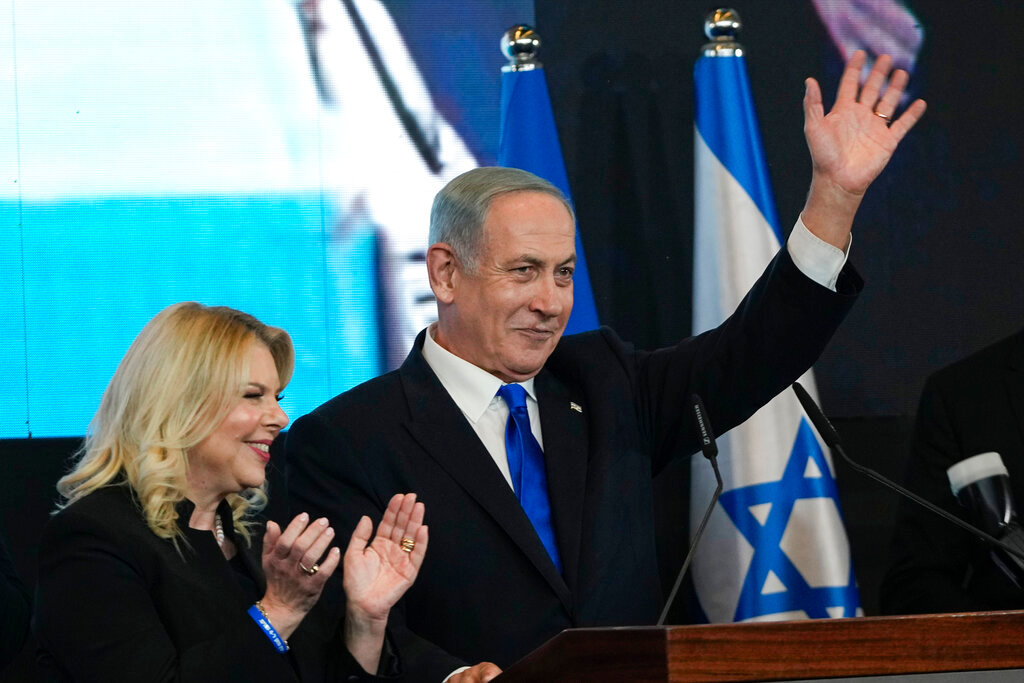 Benjamin Netanyahu, former Israeli Prime Minister and the head of Likud party, accompanied by his wife Sara waves to his supporters at his party's headquarters in Jerusalem, Wednesday, Nov. 2, 2022. (AP Photo/Tsafrir Abayov)