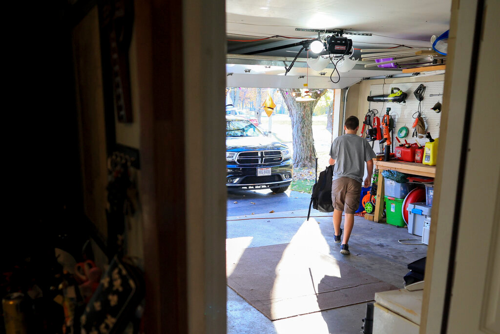 Liam Kennedy walks through his garage to put away his baseball equipment bag Friday, Oct. 28, 2022, in Monroe, Ohio. (AP Photo/Aaron Doster)