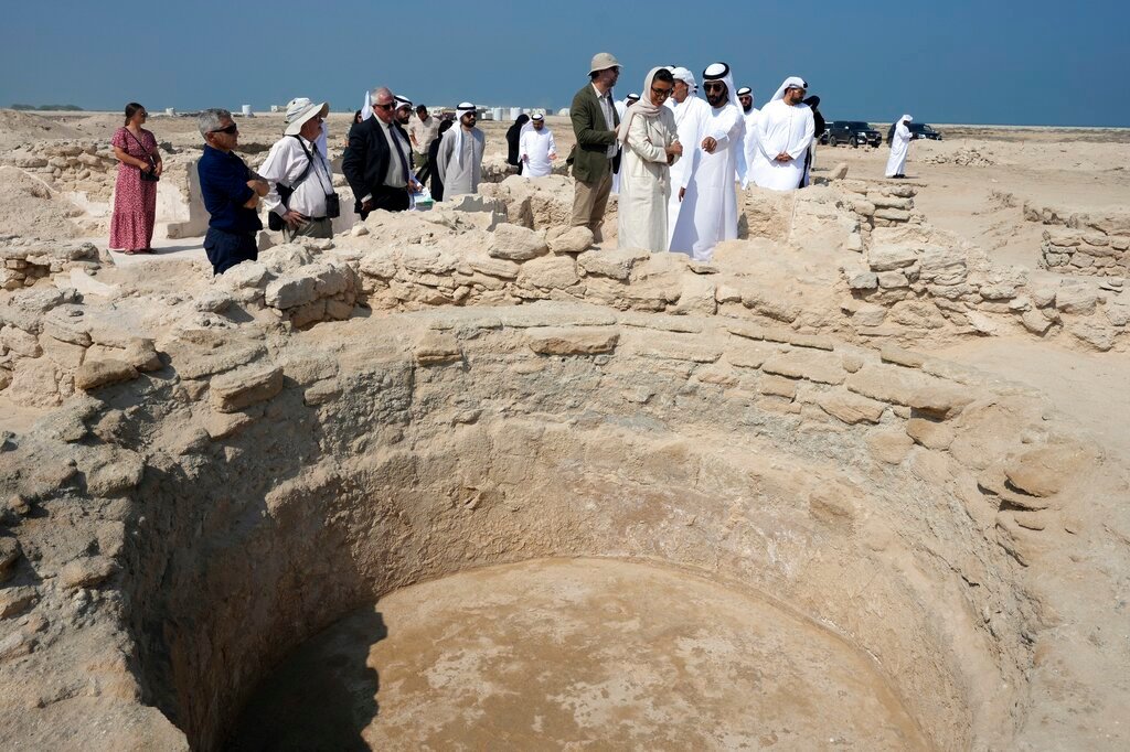 Sheikh Majid bin Saud Al Mualla, chairman of the Umm Al Quwain Department of Tourism and Archaeology, front right, explains to Noura Al Kaabi, UAE Minister of Culture and Youth, during a visit of the ancient Christian monastery on Siniyah Island in Umm al-Quwain, United Arab Emirates, Thursday, Nov. 3, 2022. (AP Photo/Kamran Jebreili)