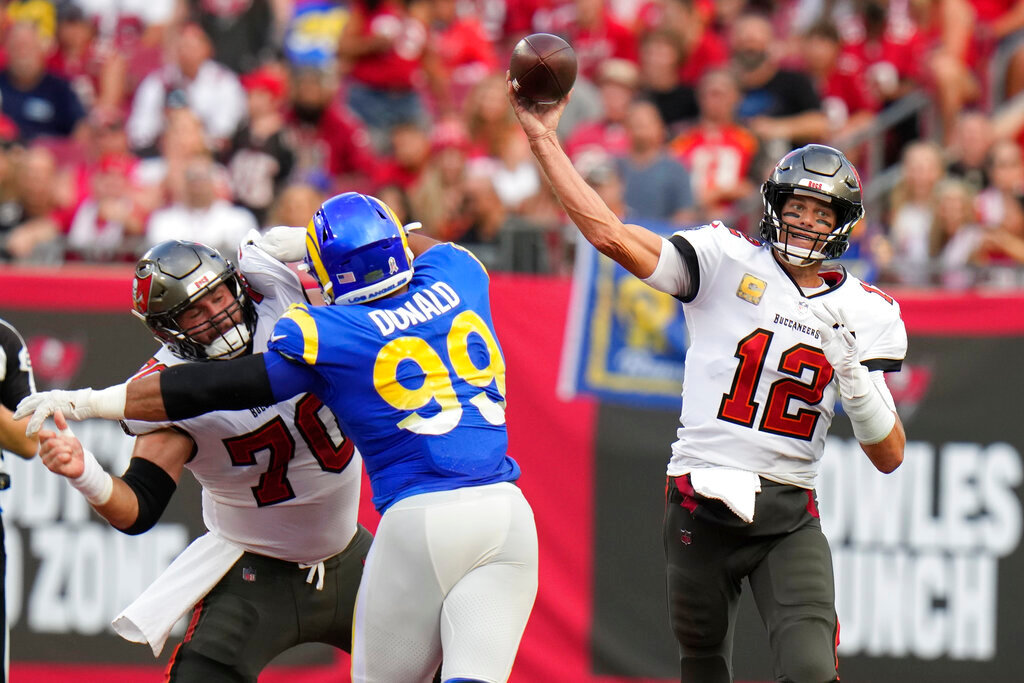 Tampa Bay Buccaneers quarterback Tom Brady (12) throws a pass as Los Angeles Rams defensive tackle Aaron Donald (99) tries to get past offensive tackle Robert Hainsey (70) during the first half Sunday, Nov. 6, 2022, in Tampa, Fla. (AP Photo/Chris O'Meara)