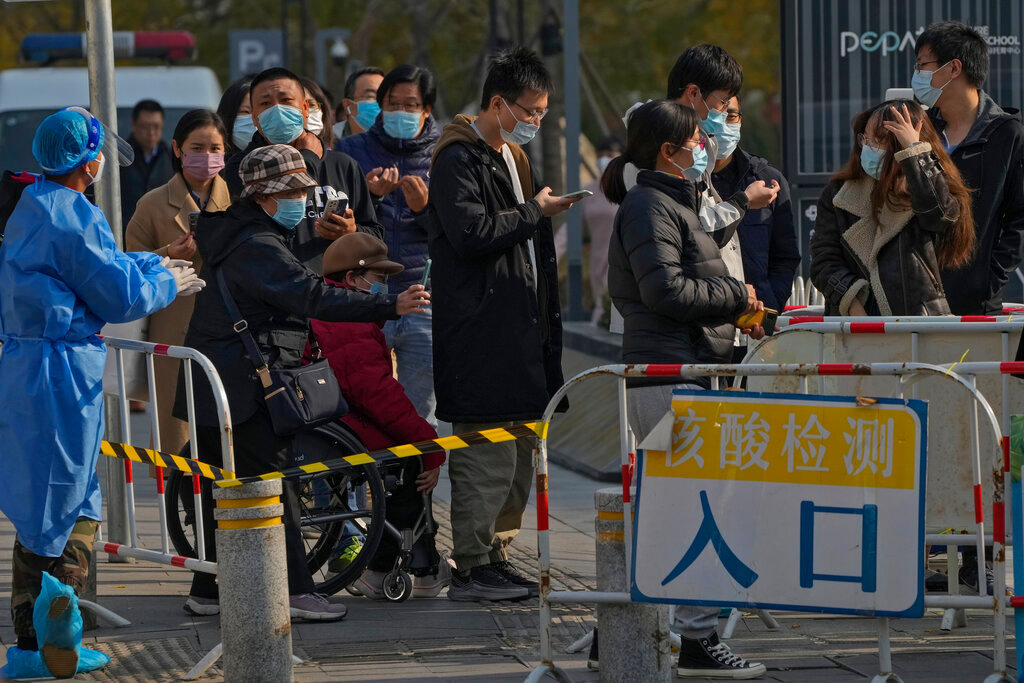 People use their smartphones to scan the health check QR codes before getting their routine COVID-19 throat swabs at a coronavirus testing site in Beijing, Tuesday, Nov. 8, 2022. (AP Photo/Andy Wong)