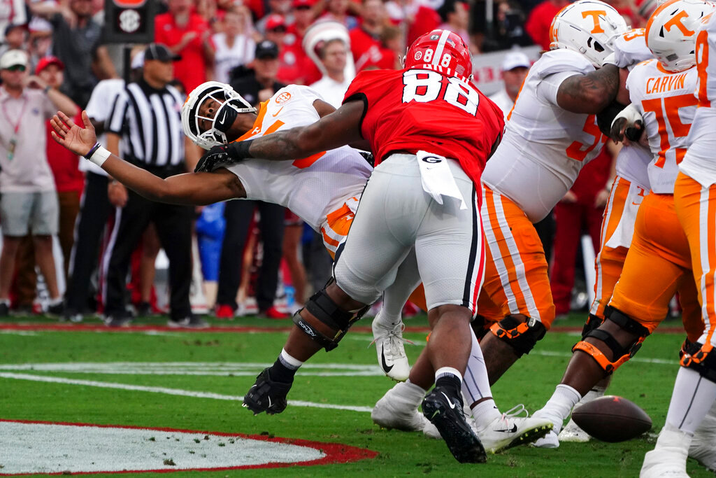 Tennessee quarterback Hendon Hooker, left, fumbles as he is hit by Georgia defensive lineman Jalen Carter (88) in the end zone during the first half Saturday, Nov. 5, 2022, in Athens, Ga. Tennessee recovered the ball and avoided a safety. (AP Photo/John Bazemore)
