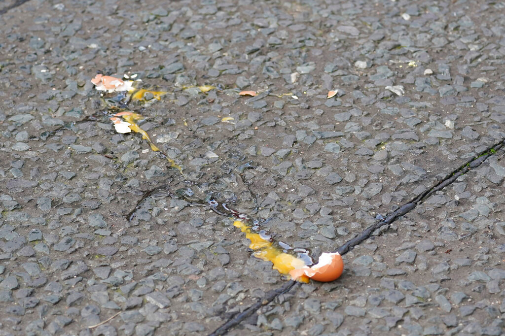 A broken egg is seen on the street after it was thrown at Britain's King Charles III and the Queen Consort as they arrived for a ceremony at Micklegate Bar, where the Sovereign is traditionally welcomed to the city, in York, England, Wednesday Nov. 9, 2022. (Jacob King/PA via AP)