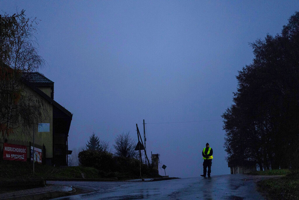 A police officer stands at a checkpoint near the scene of a blast in Przewodow, Poland, Wednesday, Nov. 16, 2022. Poland said Wednesday that a Russian-made missile fell in the country’s east, though U.S. President Joe Biden said it was “unlikely” it was fired from Russia. (AP Photo/Evgeniy Maloletka)