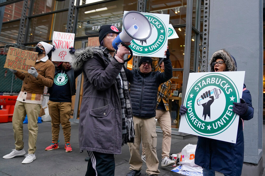 People chant and hold signs in front of a Starbucks in New York, Thursday, Nov. 17, 2022. (AP Photo/Seth Wenig)