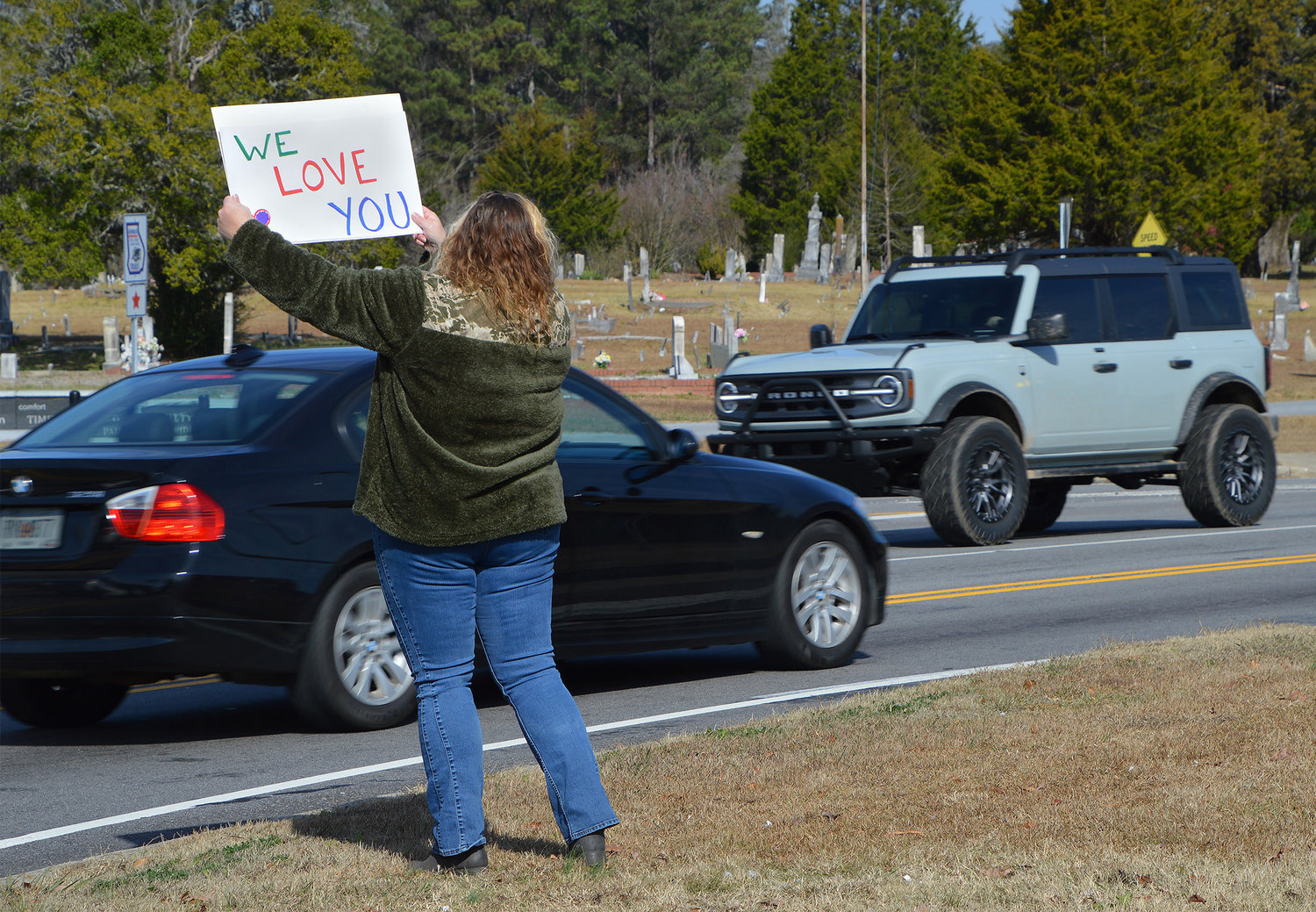 Amanda Brooks holds up a sign encouraging people to pull into New Hope First Baptist Church for drive-thru prayer on Saturday, Nov. 19, 2022, in Dallas, Ga. (Index/Henry Durand)