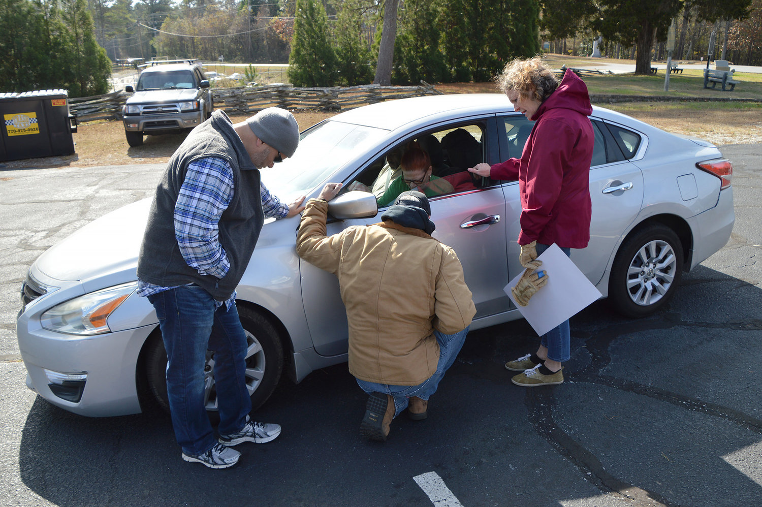 Robert Endicott, Robby Hall and Debbie Lloyd, from left, pray for Erica Mitchell after she pulled into New Hope First Baptist Church on Saturday, Nov. 19, 2022, in Dallas, Ga. Mitchell called the church's drive-up prayer ministry a "great thing."  (Index/Henry Durand)