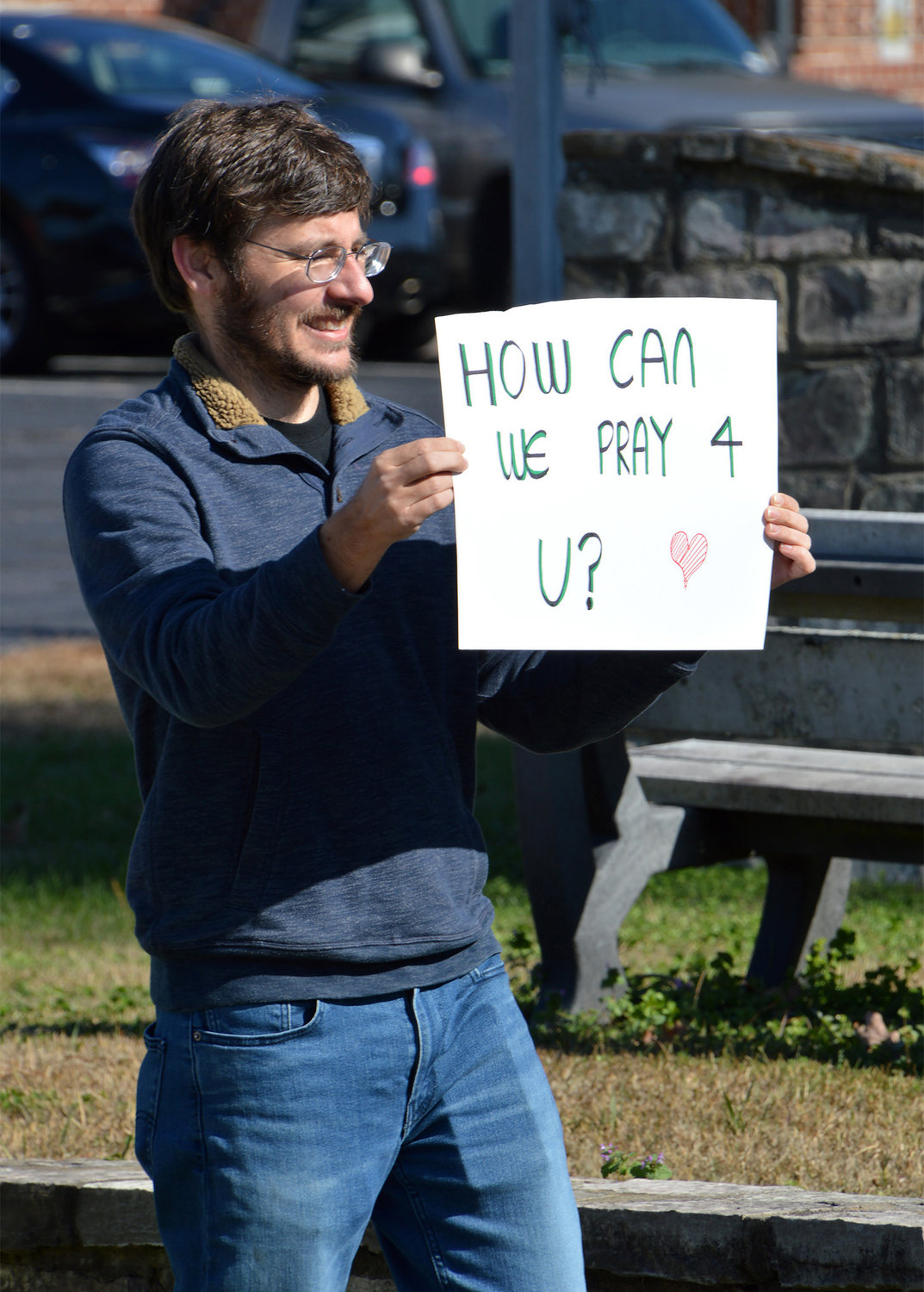 Pastor Jamie Hobbs holds up a sign encouraging people to pull into New Hope First Baptist Church for drive-thru prayer on Saturday, Nov. 19, 2022, in Dallas, Ga. (Index/Henry Durand)