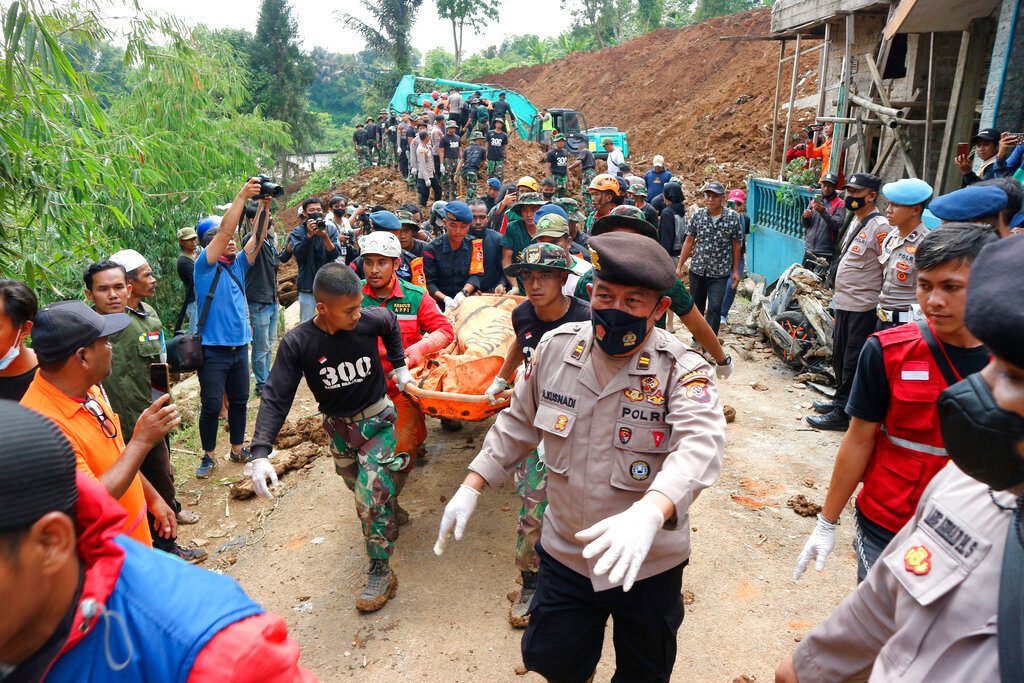 Rescuers carry the body of a victim recovered from under the rubble at a village affected by an earthquake-triggered landslide in Cianjur, West Java, Indonesia, Tuesday, Nov. 22, 2022. The earthquake has toppled buildings on Indonesia's densely populated main island, killing a number of people and injuring hundreds. (AP Photo/Rangga Firmansyah)