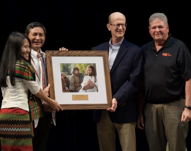 Mang Siing, second from left, receives a framed still of the Jesus film as a gift for helping translate the film into its 2,000th language.