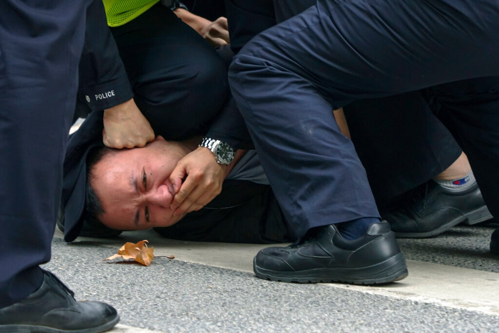 Policemen pin down and arrest a protester during a protest on a street in Shanghai, China, Sunday, Nov. 27, 2022. (AP Photo)
