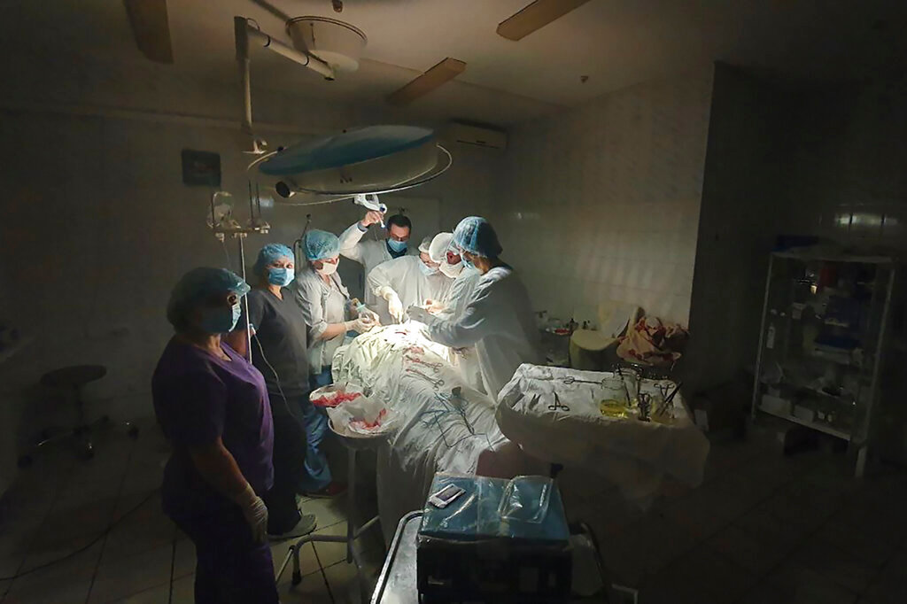 This photo made available by Ukrainian doctor Oleh Duda shows the moment when lights at a hospital went out as he was performing surgery on a bleeding patient at the hospital in the western city of Lviv, Ukraine, Tuesday, Nov. 15, 2022. (Oleh Duda via AP)