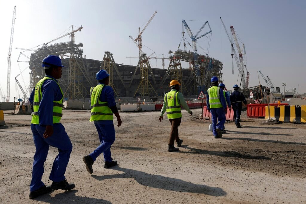 Workers walk to the Lusail Stadium, one of the 2022 World Cup stadiums, in Lusail, Qatar, Friday, Dec. 20, 2019. (AP Photo/Hassan Ammar, File)