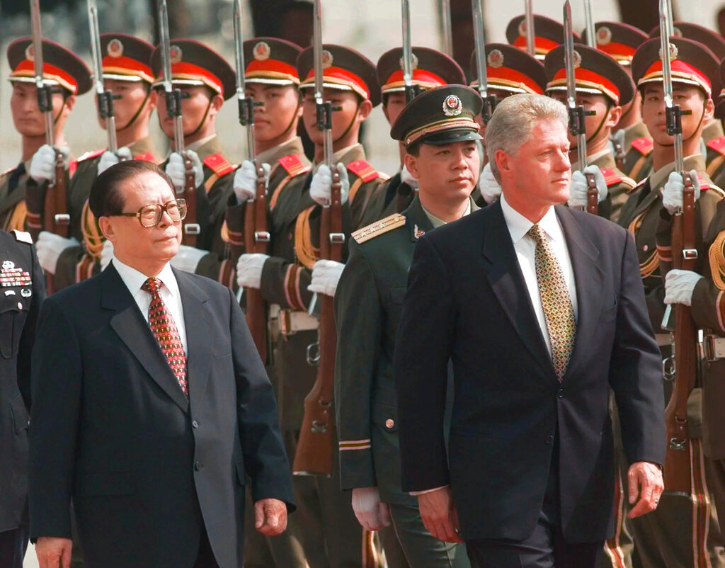 U.S. President Bill Clinton, right, and Chinese President Jiang Zemin, left, review Chinese troops during arrival ceremonies at east the plaza of the Great Hall of the People in Beijing, June 27, 1998. (AP Photo/David Longstreath, File)
