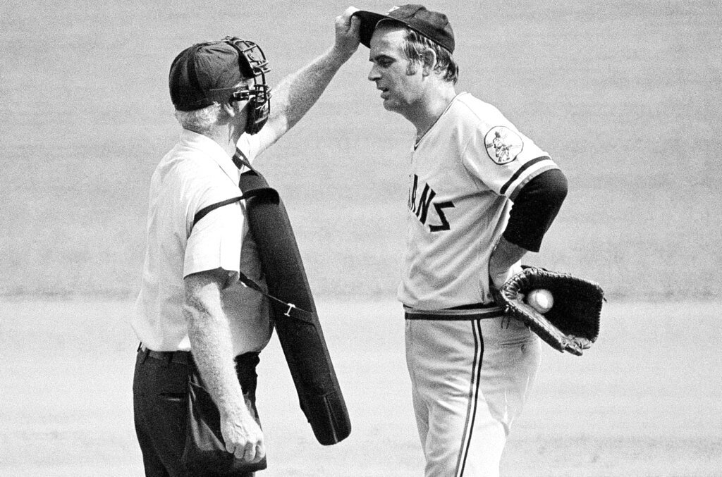 Home plate umpire John Flaherty checks Cleveland Indians pitcher Gaylord Perry's cap for an illegal substance, at the request of Milwaukee Brewers manager Del Crandall, during the first game of a doubleheader in Milwaukee, Sept. 3, 1973. Perry, a baseball Hall of Famer and two-time Cy Young winner, died Thursday, Dec. 1, 2022, at his home in Gaffney, S.C. (AP Photo/File)