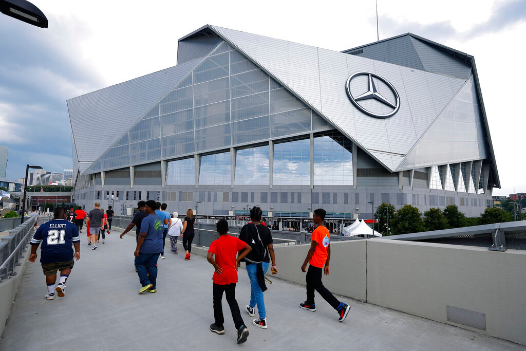 Fans walk toward the entrance of Mercedes-Benz Stadium as the Atlanta Falcons hosted an open practice in Atlanta, Aug. 15, 2022. (AP Photo/Todd Kirkland, File)