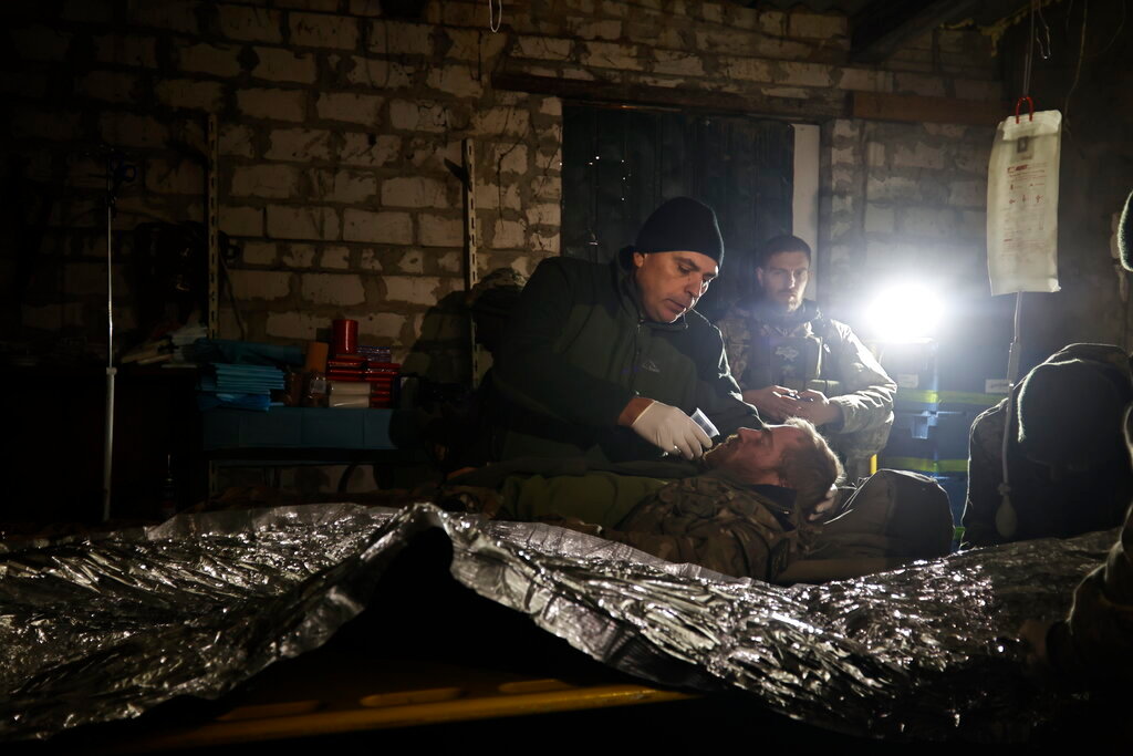 Ukrainian servicemen give first aid to a soldier wounded in a battle with Russian troops in their shelter in the Donetsk region, Ukraine, Thursday, Dec. 1, 2022. (AP Photo/Roman Chop)