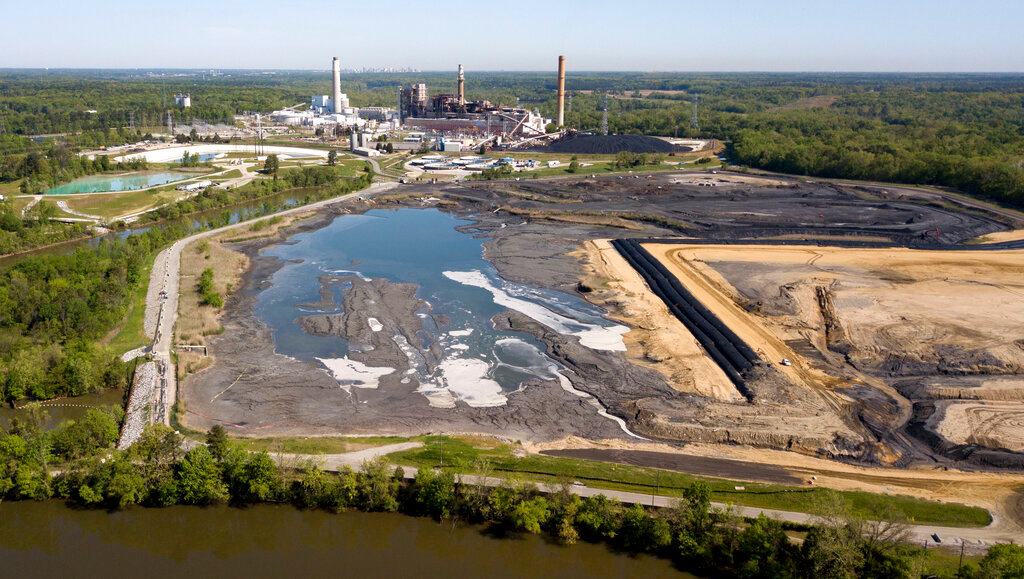 The Richmond, Va., city skyline is seen on the horizon behind the coal ash ponds along the James River near Dominion Energy's Chesterfield Power Station in Chester, Va., May 1, 2018. (AP Photo/Steve Helber, File)