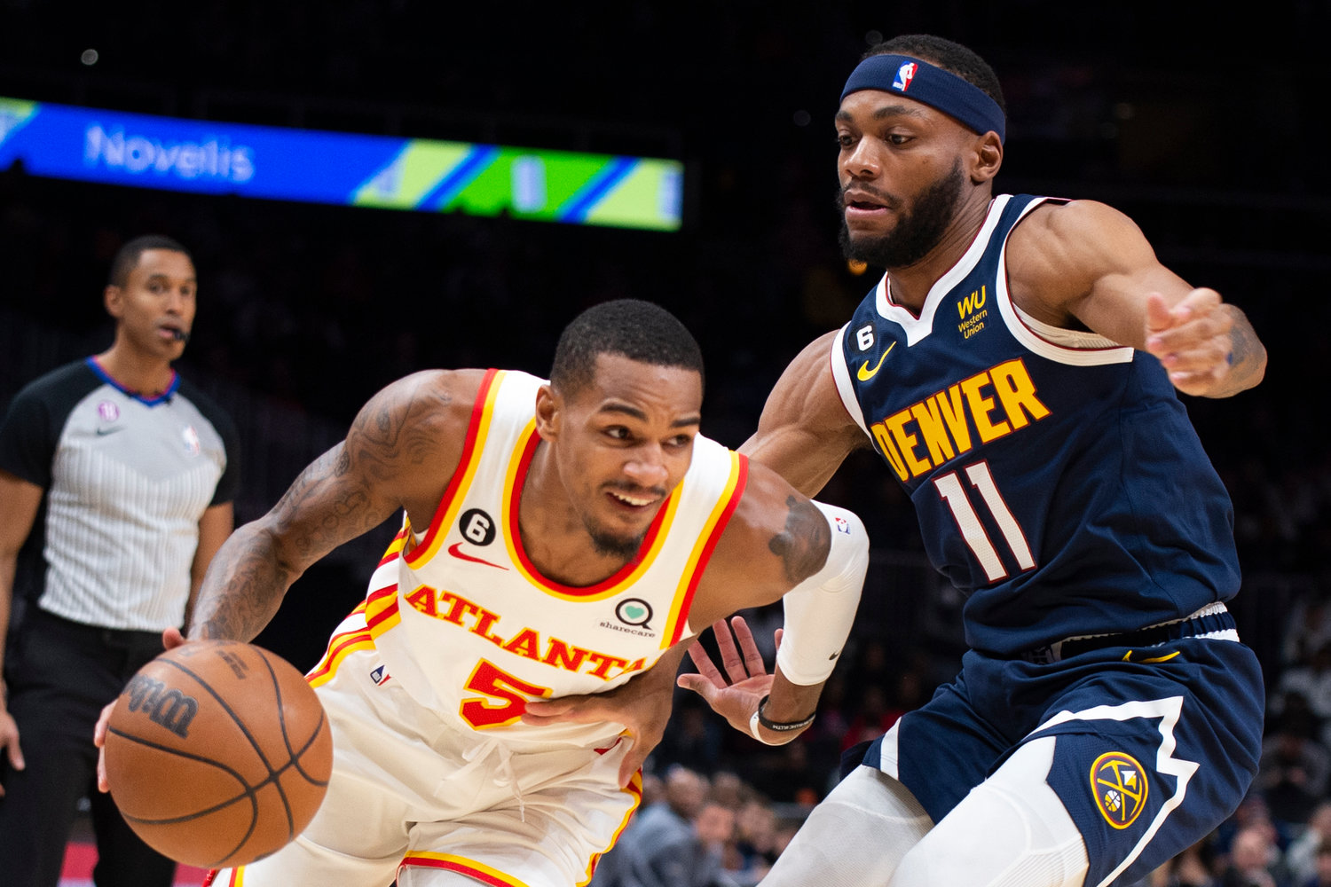 Atlanta Hawks guard Dejounte Murray drives to the basket past Denver Nuggets forward Bruce Brown during the first half of an NBA basketball game Friday, Dec. 2, 2022, in Atlanta. (AP Photo/Hakim Wright Sr.)