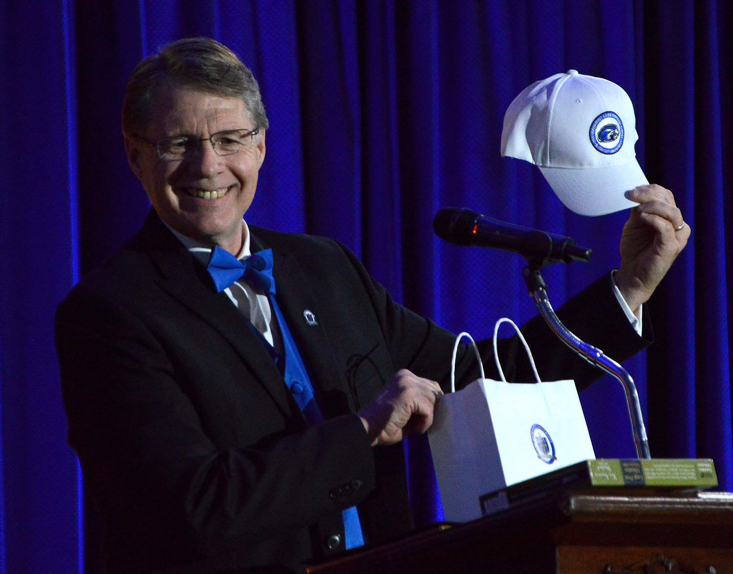 Shorter University President Dr. Don Dowless holds up a Shorter baseball cap that he presented to Darryl Strawberry at the President’s Gala in Rome, Ga., Dec. 1, 2022. (Index/Henry Durand)
