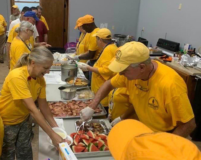 Georgia Baptist Disaster Relief volunteers, in their trademark yellow shirts and caps, feed crowds in crisis situations across the state and nation, as was the case in this file photo from Kentucky last year. This week they're feeding the men and women providing security around former first lady Rosalynn Carter's memorial services. (Photo/Georgia Baptist Disaster Relief, File)
