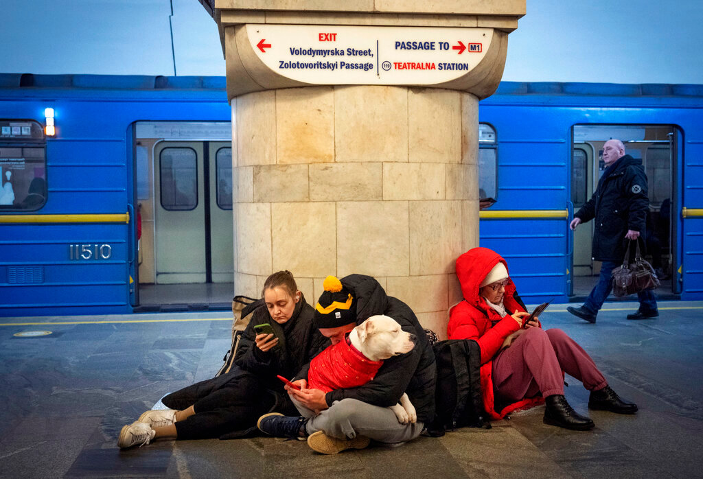 People sit in a subway station being used as a bomb shelter during a rocket attack in Kyiv, Ukraine, Thursday, Dec. 29, 2022. (AP Photo/Efrem Lukatsky)