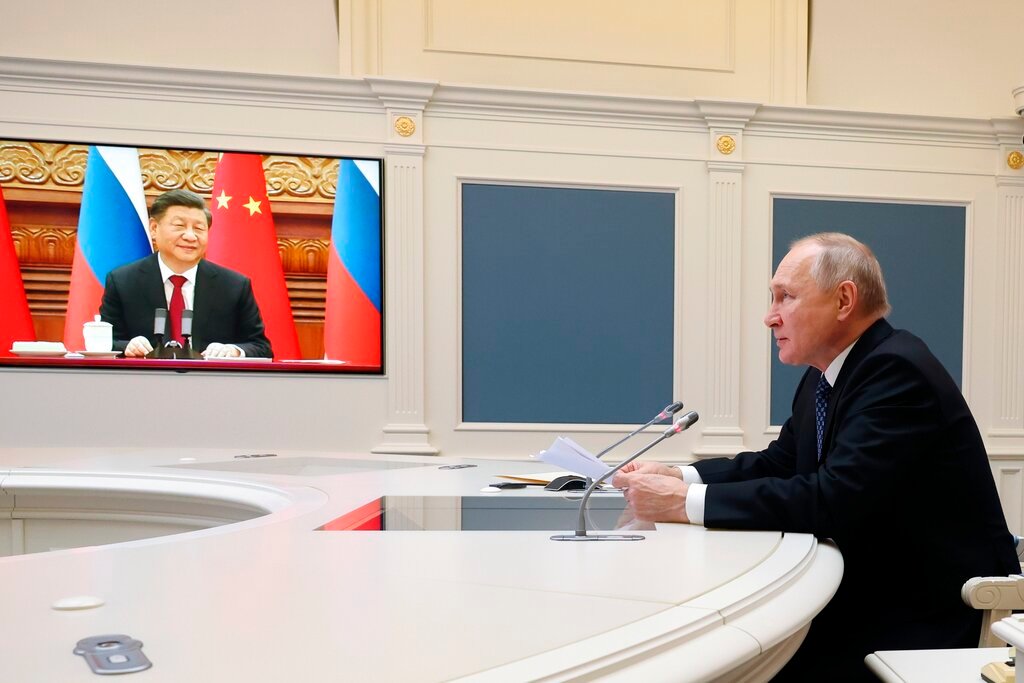 Russian President Vladimir Putin speaks during a meeting with Chinese President Xi Jinping, seen onscreen, via a video conference at the Kremlin in Moscow, Russia, Friday, Dec. 30, 2022. (Mikhail Klimentyev, Sputnik, Kremlin Pool Photo via AP)