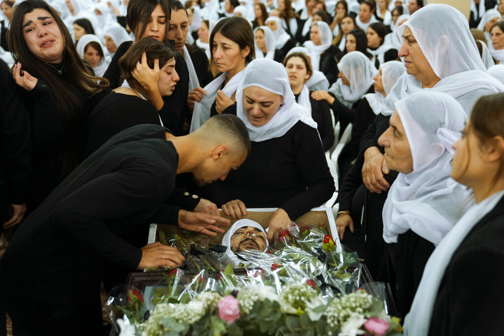 Members of the Israeli Druze minority mourn around the body of Tiran Fero, 17, during his funeral in Daliyat al-Carmel, Israel, on Nov. 24, 2022. (AP Photo/Mahmoud Illean, File)