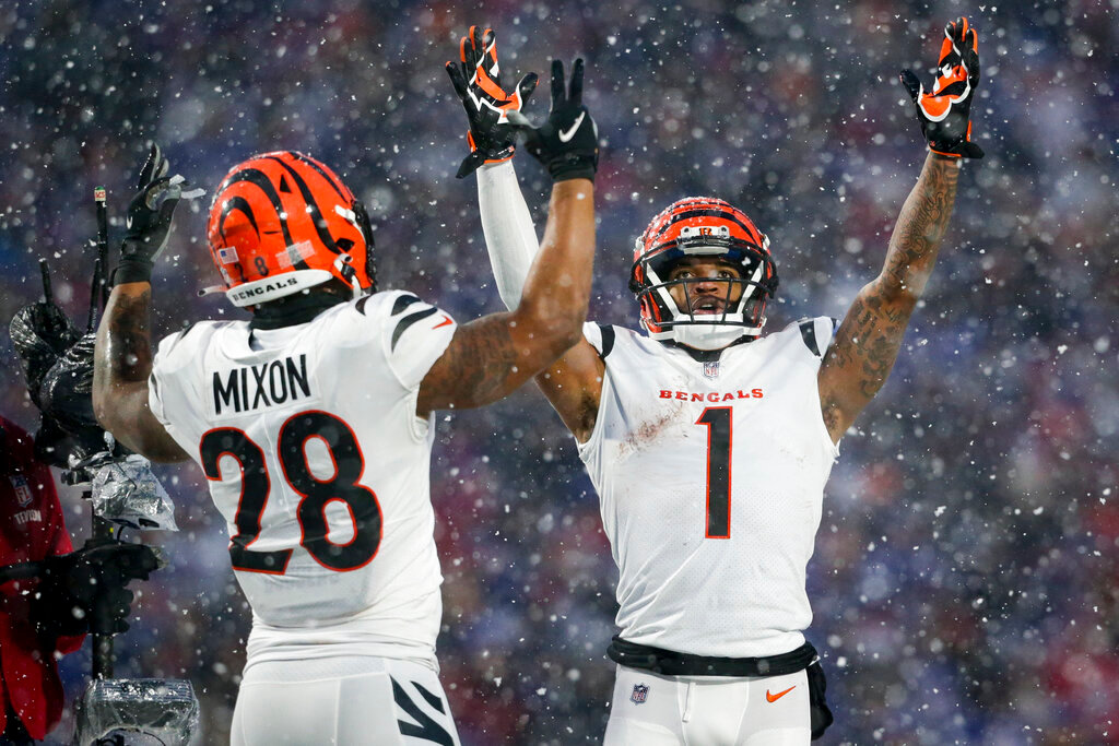 Cincinnati Bengals wide receiver Ja'Marr Chase (1) and Cincinnati Bengals running back Joe Mixon (28) motion for a touchdown against the Buffalo Bills during the third quarter of an NFL division round game Sunday, Jan. 22, 2023, in Orchard Park, N.Y. (AP Photo/Joshua Bessex)