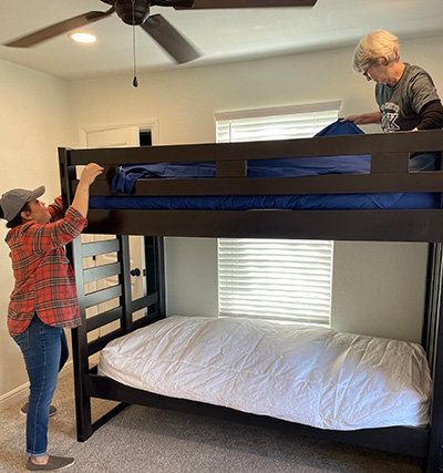 Marisol Sandoval, left, and Freddie Martinka with the Woman’s Missionary of Texas staff help put sheets on a bunk bed at Mary’s House. (Photo/Southwestern Baptist Theological Seminary)
