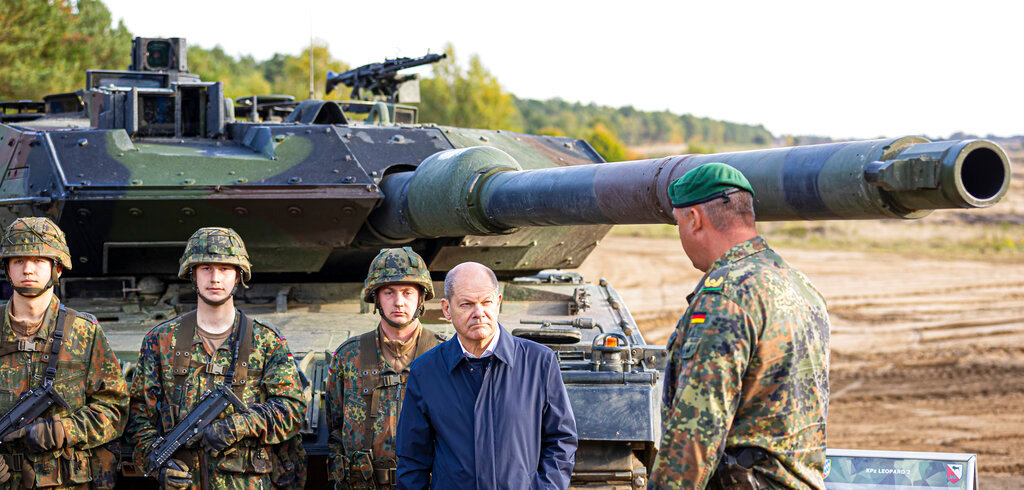 German Chancellor Olaf Scholz stands with German army Bundeswehr soldiers beside a Leopard 2 main battle tank during a training and instruction exercise in Ostenholz, Germany, Oct. 17, 2022. (Moritz Frankenberg/dpa via AP, File)