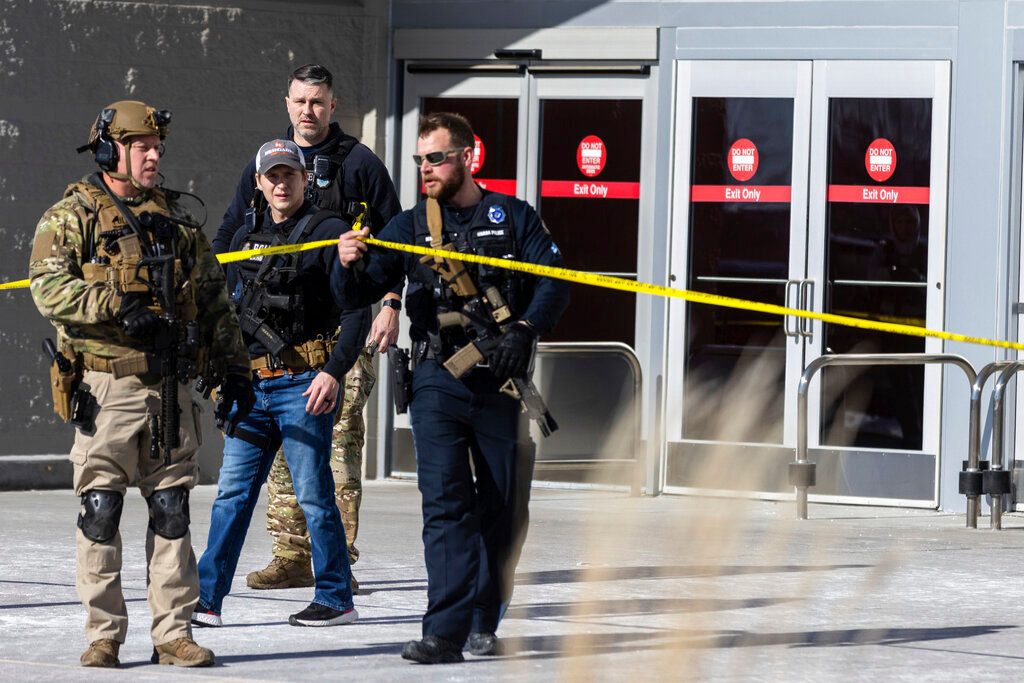 Law enforcement officers exit a Target store after a man with an AR-15-style rifle and more than a dozen ammunition magazines opened fire, in Omaha, Neb., Tuesday, Jan. 31, 2023. The man was killed by police. (Chris Machian/Omaha World-Herald via AP)