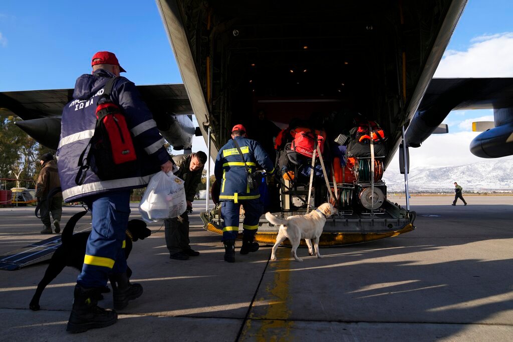 Greek firefighters with dogs board a military plane at Elefsina Air Force Base, in western Athens, Greece, Monday, Feb. 6, 2023. (AP Photo/Thanassis Stavrakis)